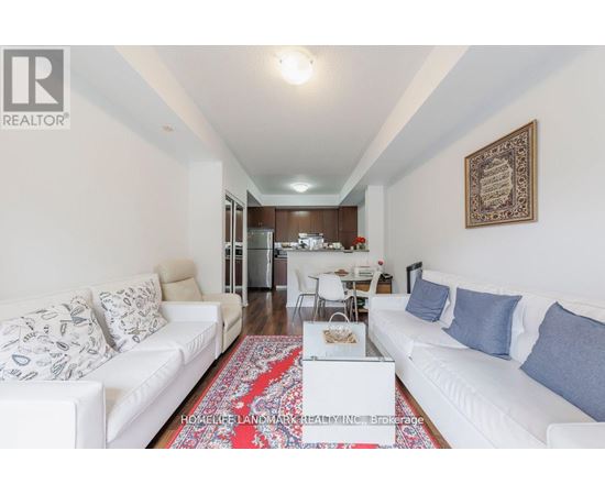 A living room with a white couch and a rug on the floor.
