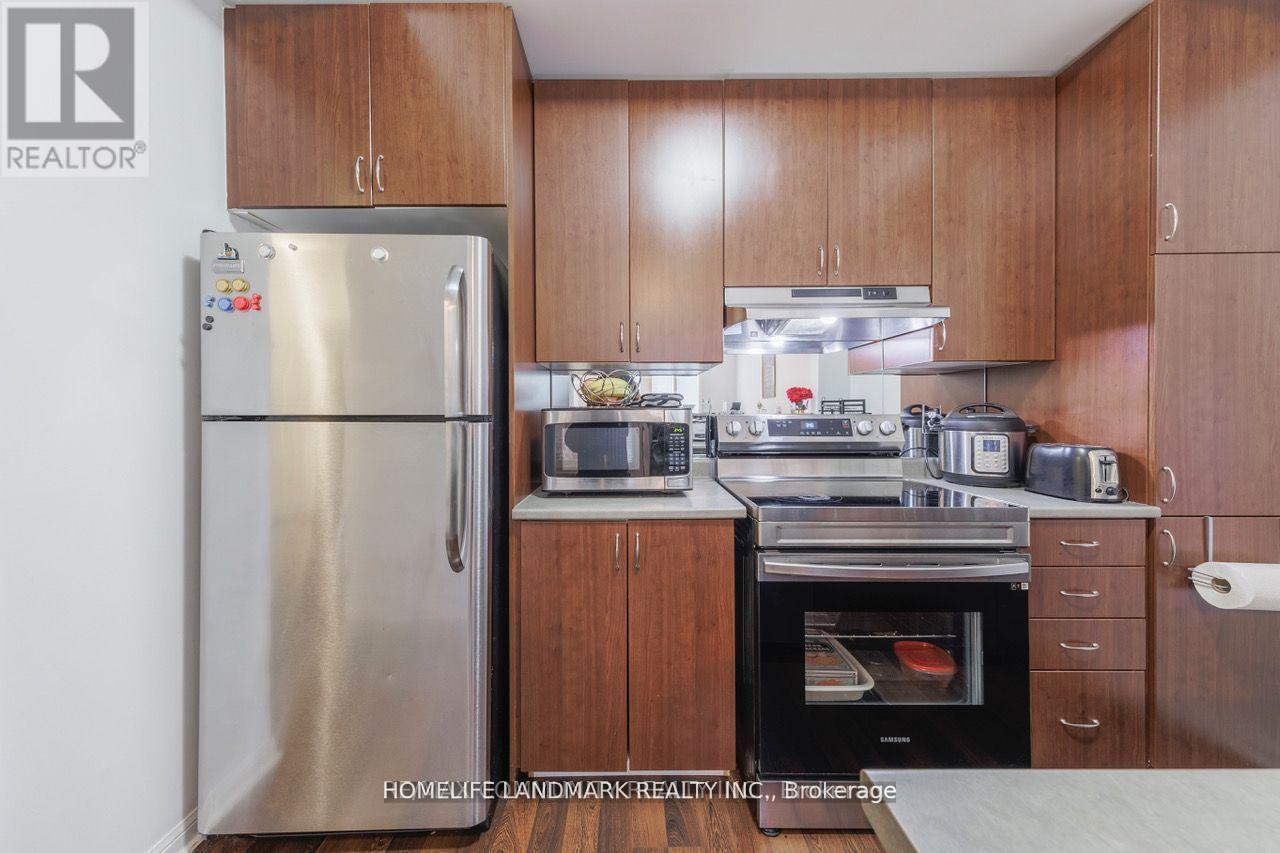 A kitchen with wooden cabinets and a stainless steel refrigerator.