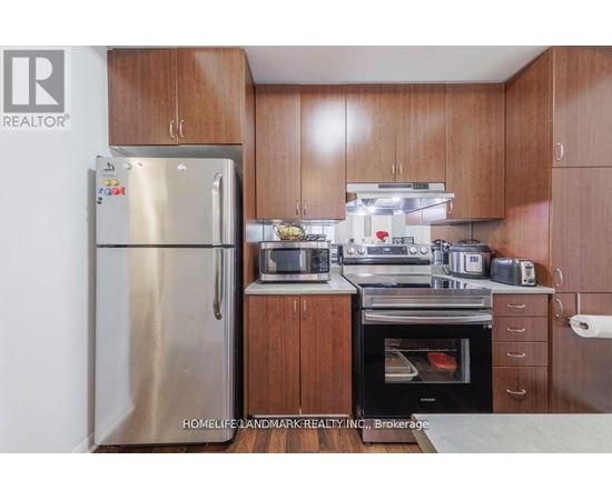 A kitchen with wooden cabinets and a stainless steel refrigerator.
