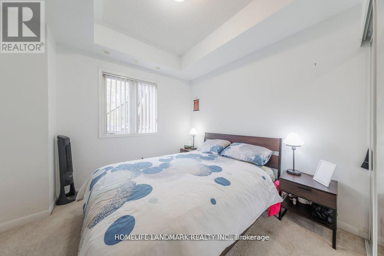 A bedroom with a bed, nightstand, and window.