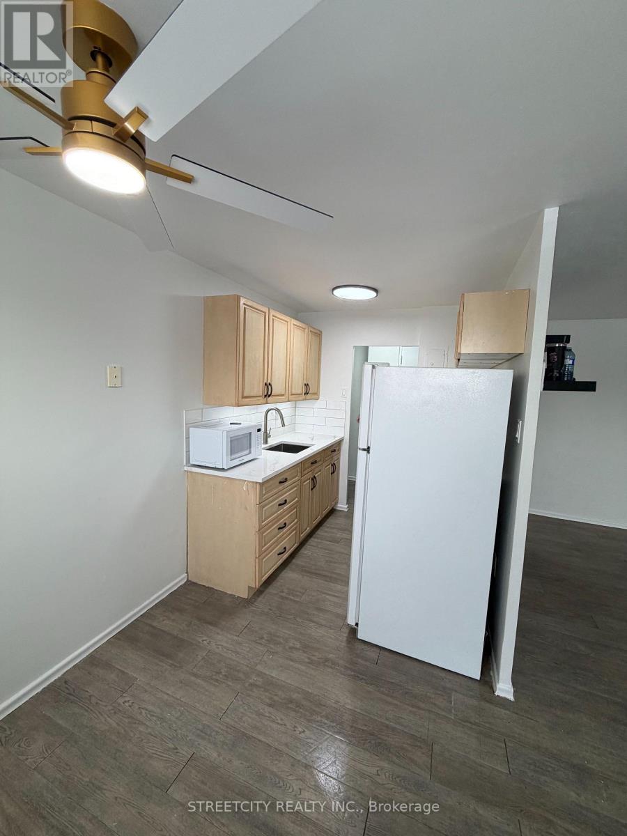 A kitchen with white appliances and wooden cabinets.