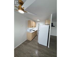 A kitchen with white appliances and wooden cabinets.