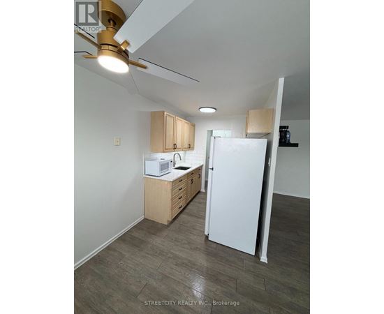 A kitchen with white appliances and wooden cabinets.
