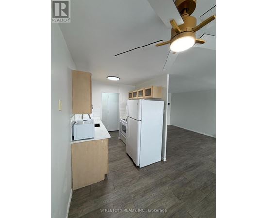 A kitchen with a refrigerator, microwave, and oven is being set up.