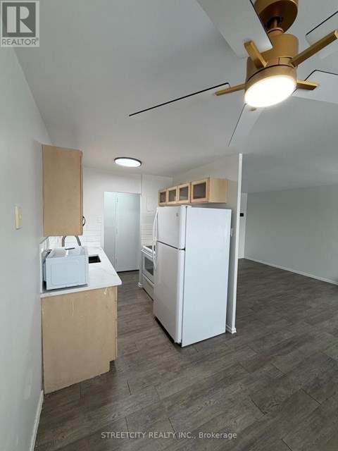 A kitchen with a refrigerator, microwave, and oven is being set up.