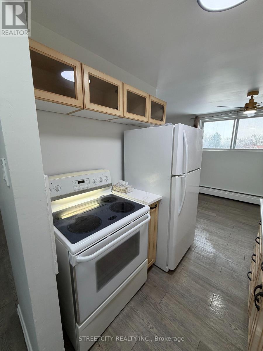 A kitchen with a white oven and refrigerator.