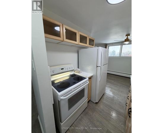 A kitchen with a white oven and refrigerator.