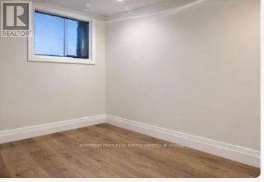 A room with a window and wooden flooring.