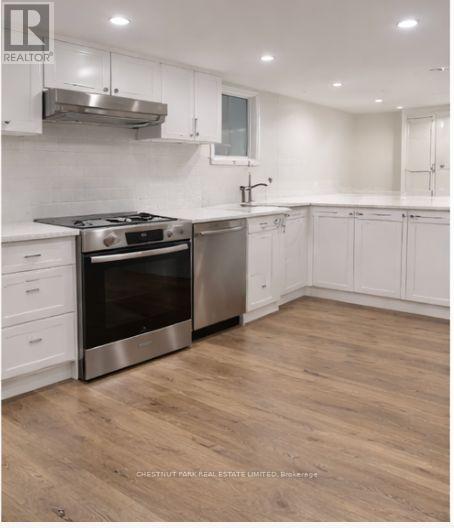 A modern kitchen with white cabinets and a stainless steel oven.