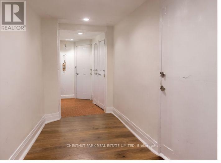 A hallway with white walls and wood floors.