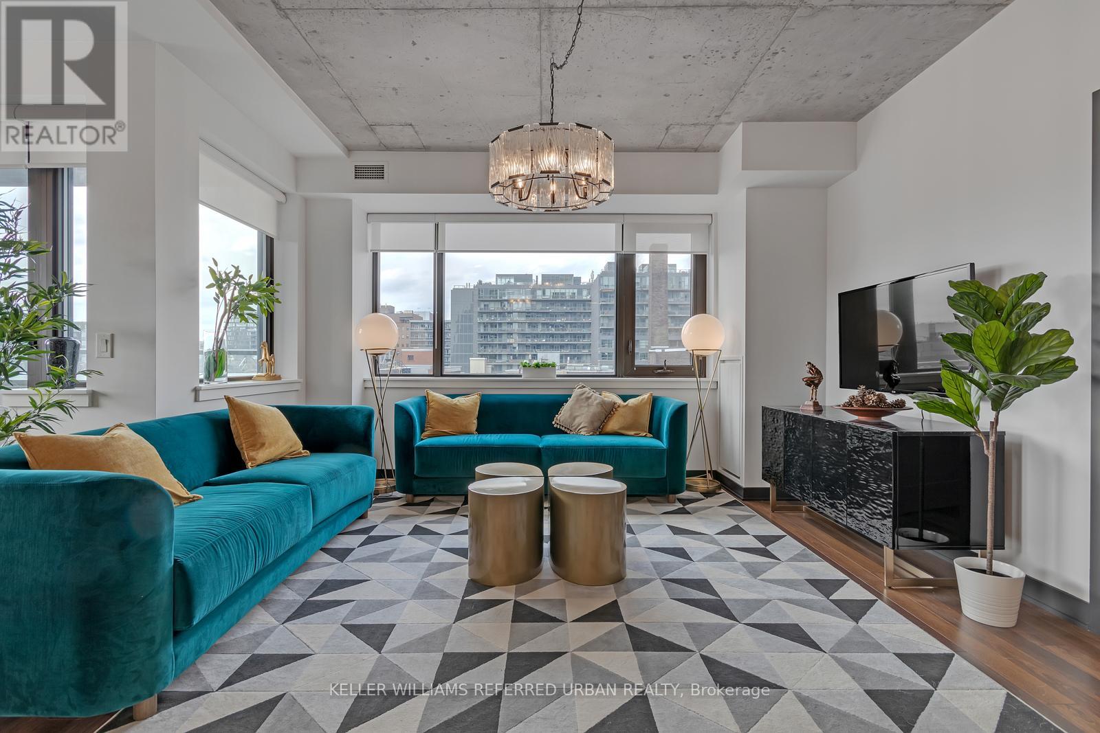 A living room with a blue couch and a chandelier.