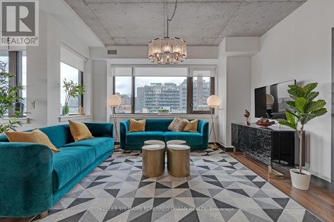 A living room with a blue couch and a chandelier.