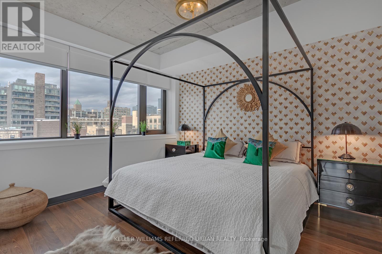 A bedroom with a canopy bed and a city view.