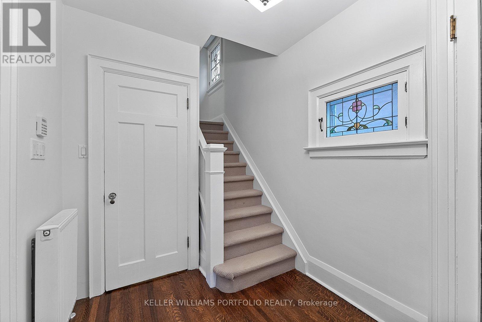 A white cabinet with glass doors is open, revealing a living room with a fireplace.