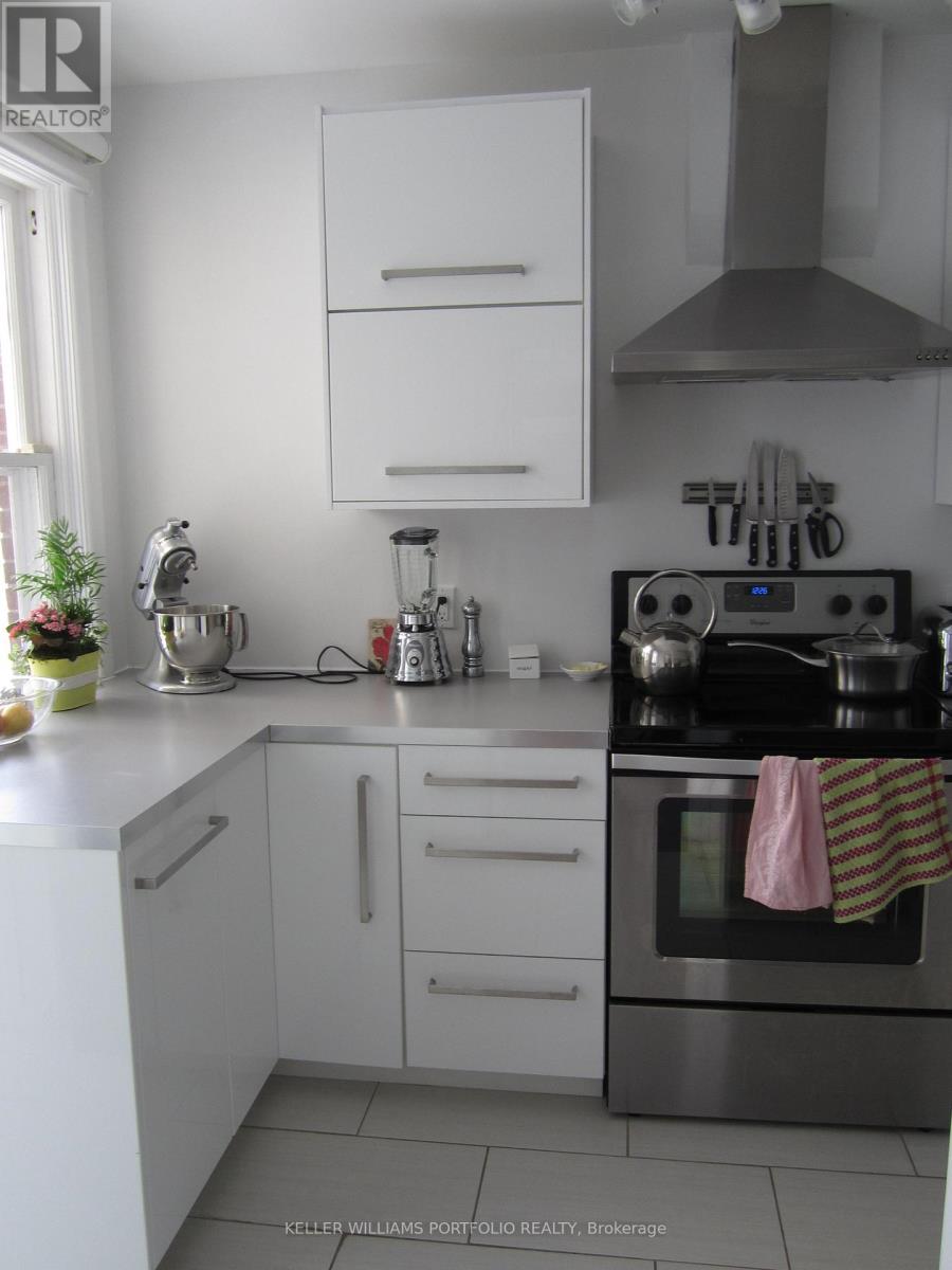 A modern kitchen with white cabinets and stainless steel appliances.