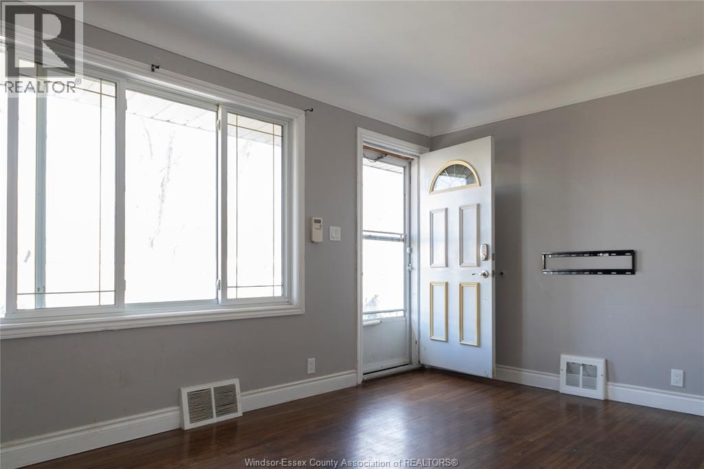 A room with a white door and a window with blinds.