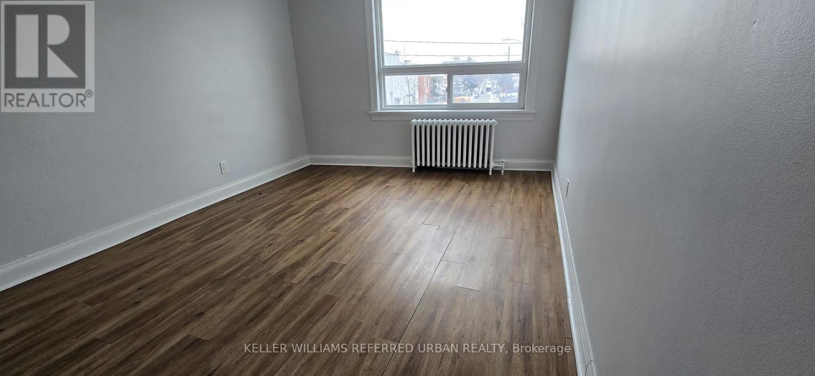 A room with a window and a radiator on the wall.