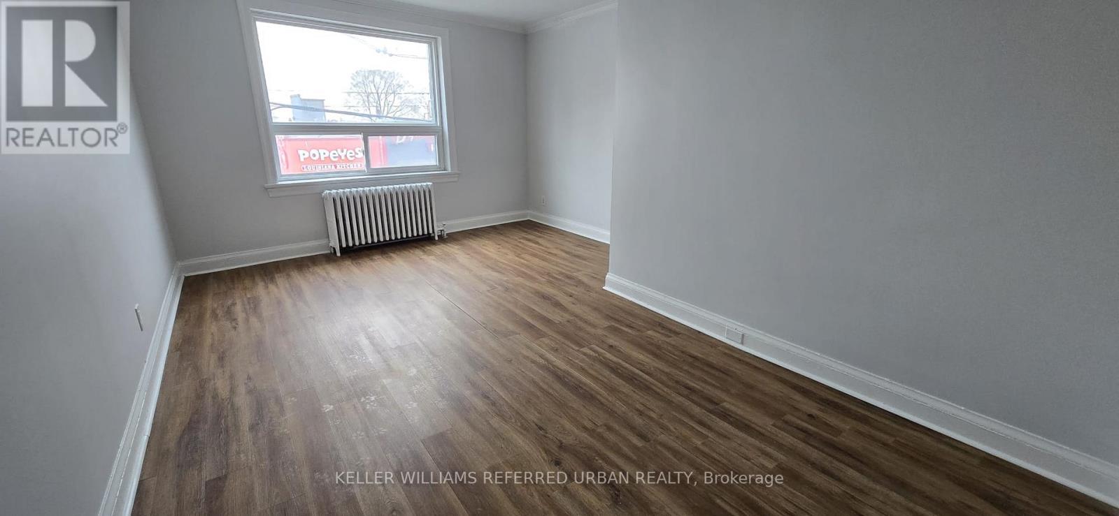 A room with a window and a radiator on the wall.