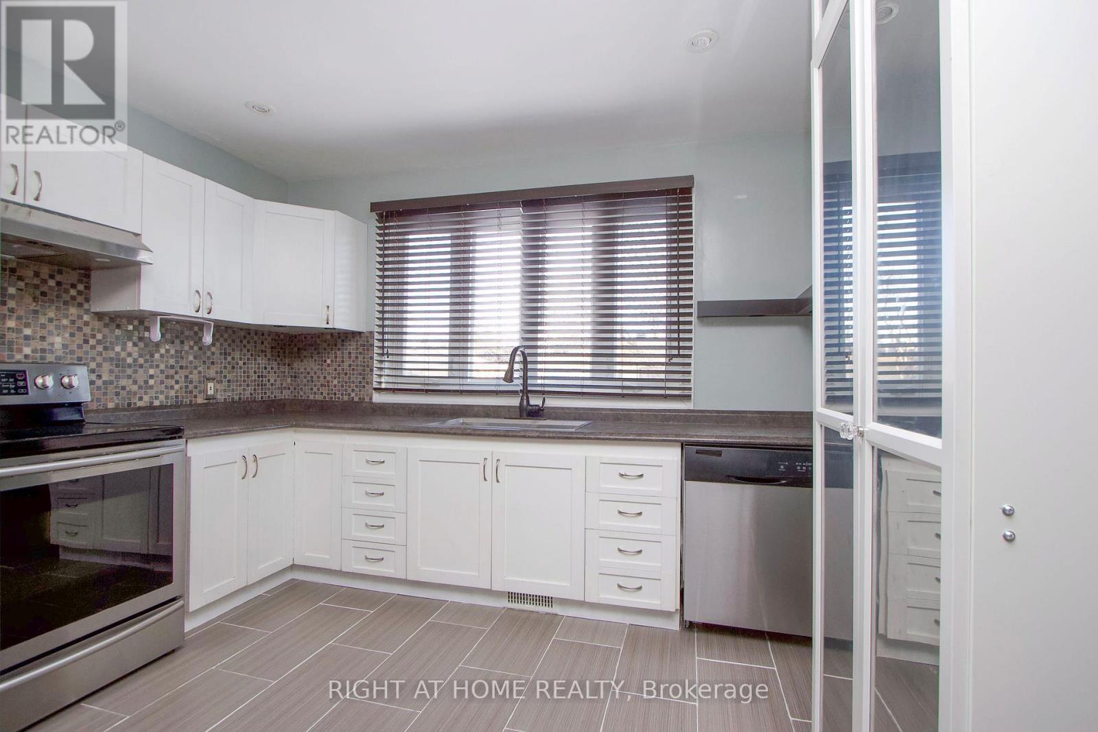A kitchen with white cabinets and a black stove top oven.