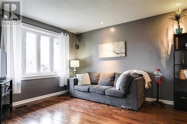A living room with a grey couch and a painting on the wall.