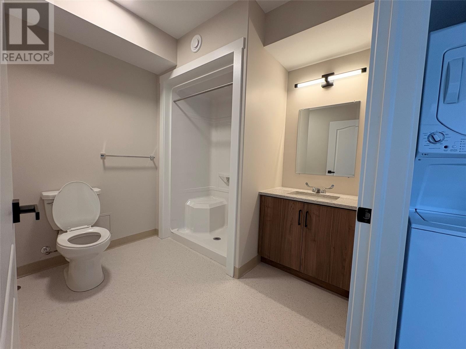A bathroom with a toilet, sink, and shower.