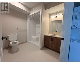 A bathroom with a toilet, sink, and shower.
