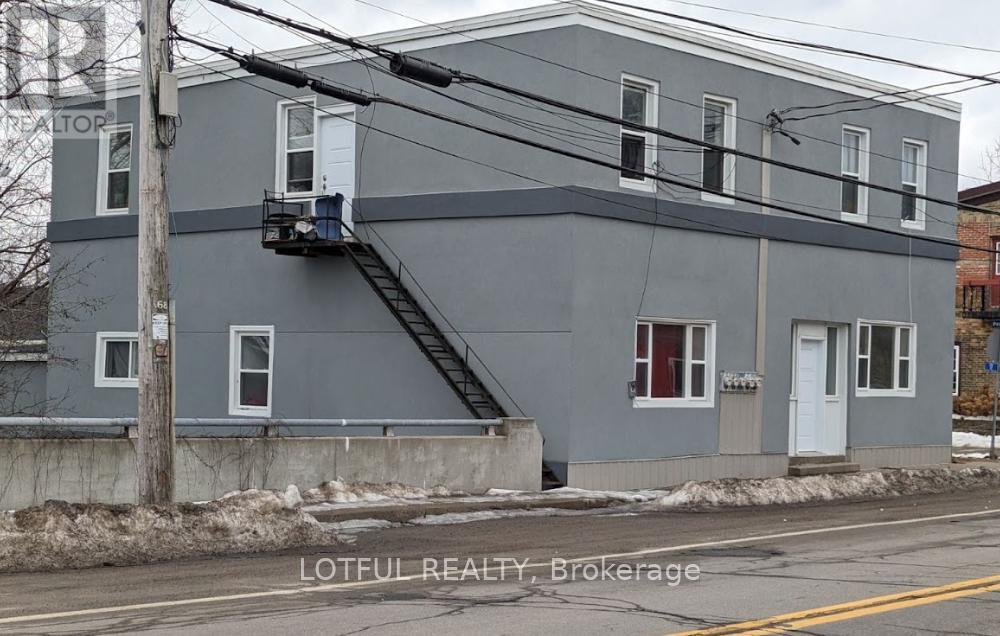 A grey building with a staircase leading to the second floor.