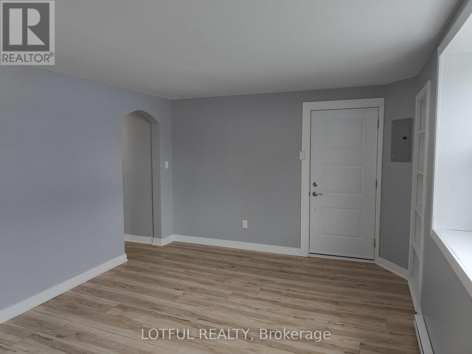 A room with wooden flooring and a white door.