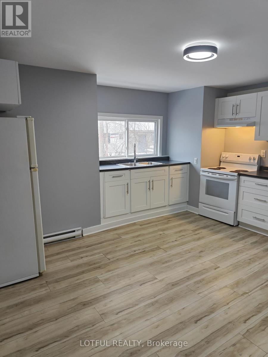 A kitchen with wooden floors and white appliances.