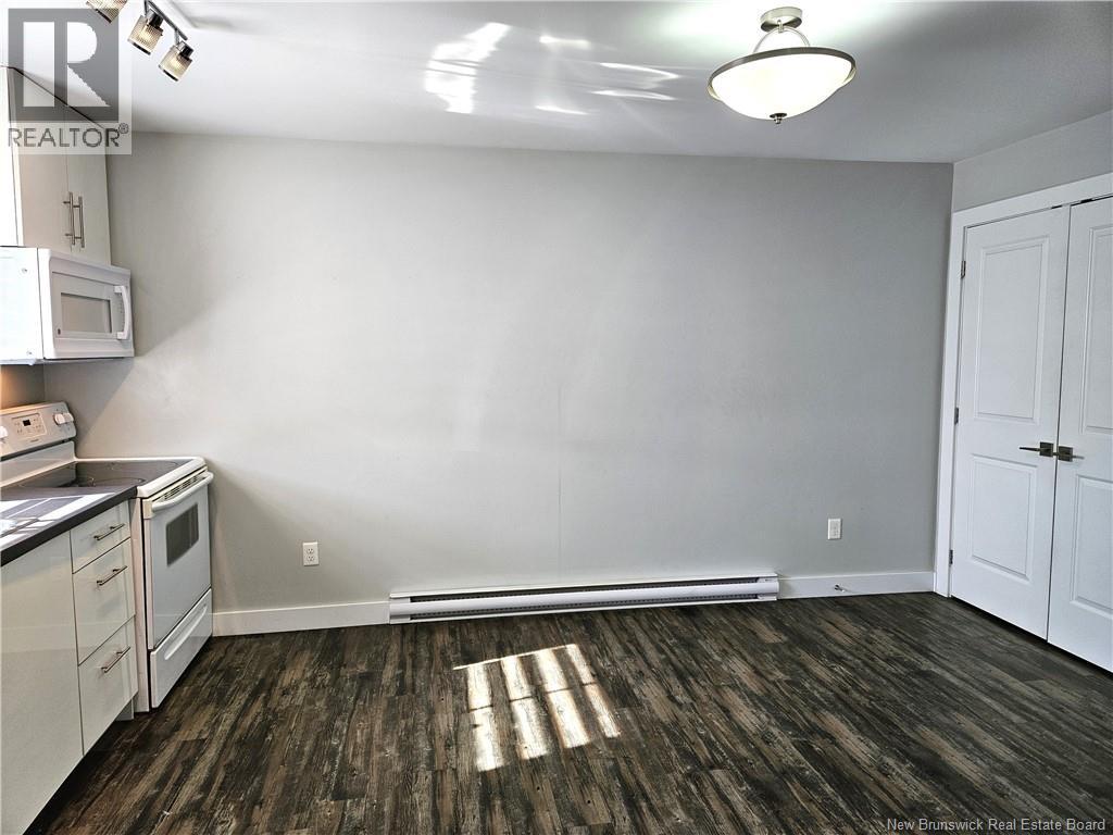 A kitchen with white cabinets and a microwave.