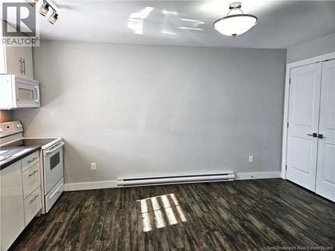 A kitchen with white cabinets and a microwave.