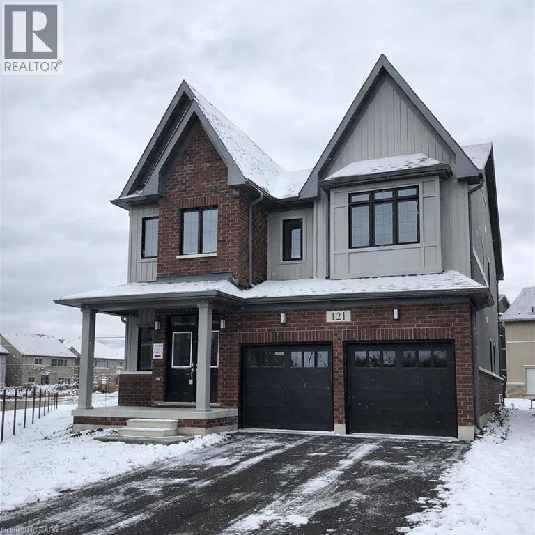 A house with a snow-covered roof and garage doors.