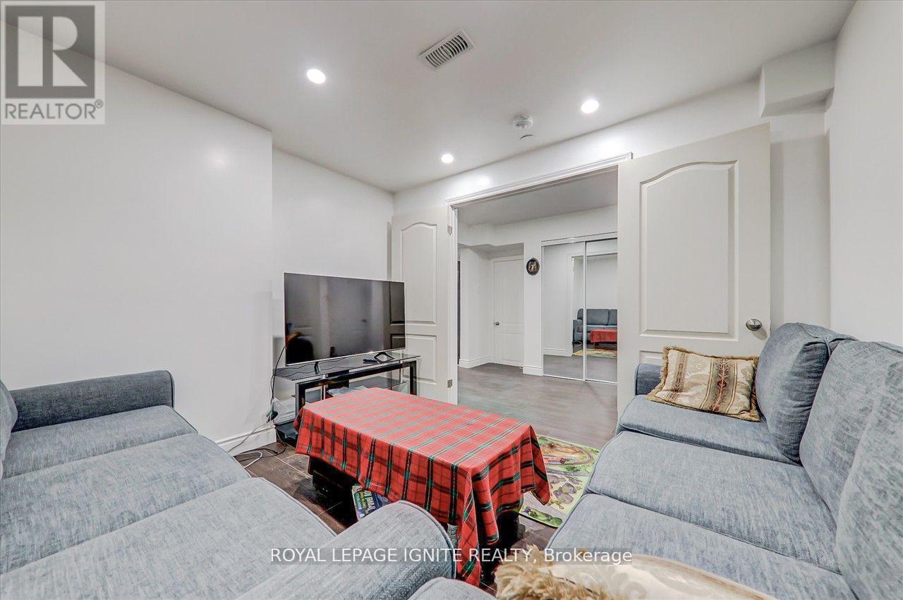 A living room with a grey couch and a red and black checkered tablecloth on the table.