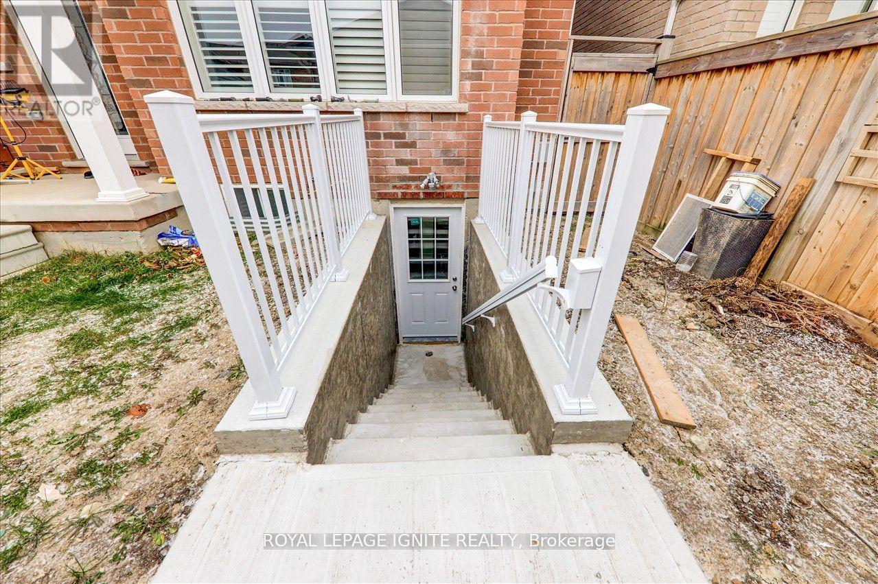 A white railing is in front of a brick building.