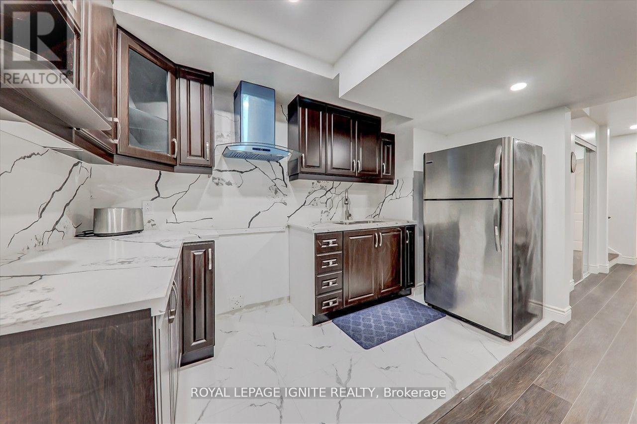 A kitchen with a marble counter top and stainless steel appliances.
