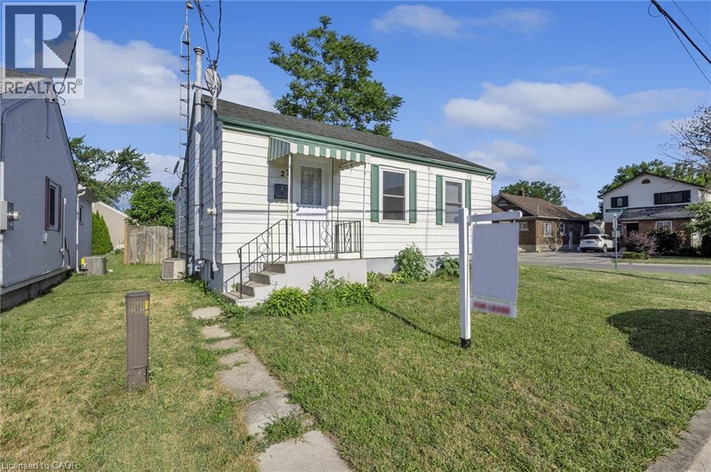 A house with a green lawn and a sign in front of it.