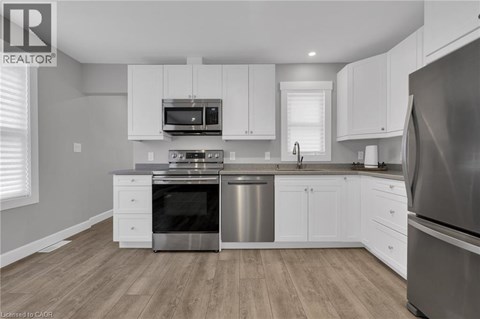 A modern kitchen with white cabinets and stainless steel appliances.