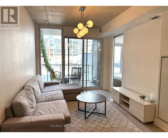 A living room with a grey couch and a round table.