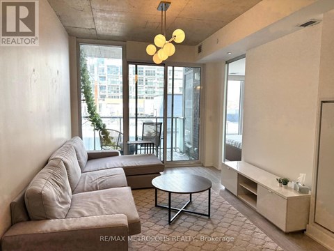 A living room with a grey couch and a round table.