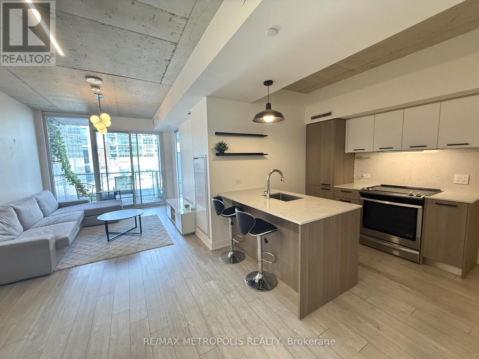 A modern kitchen with a bar stool and a dining table.