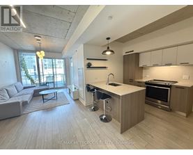 A modern kitchen with a bar stool and a dining table.