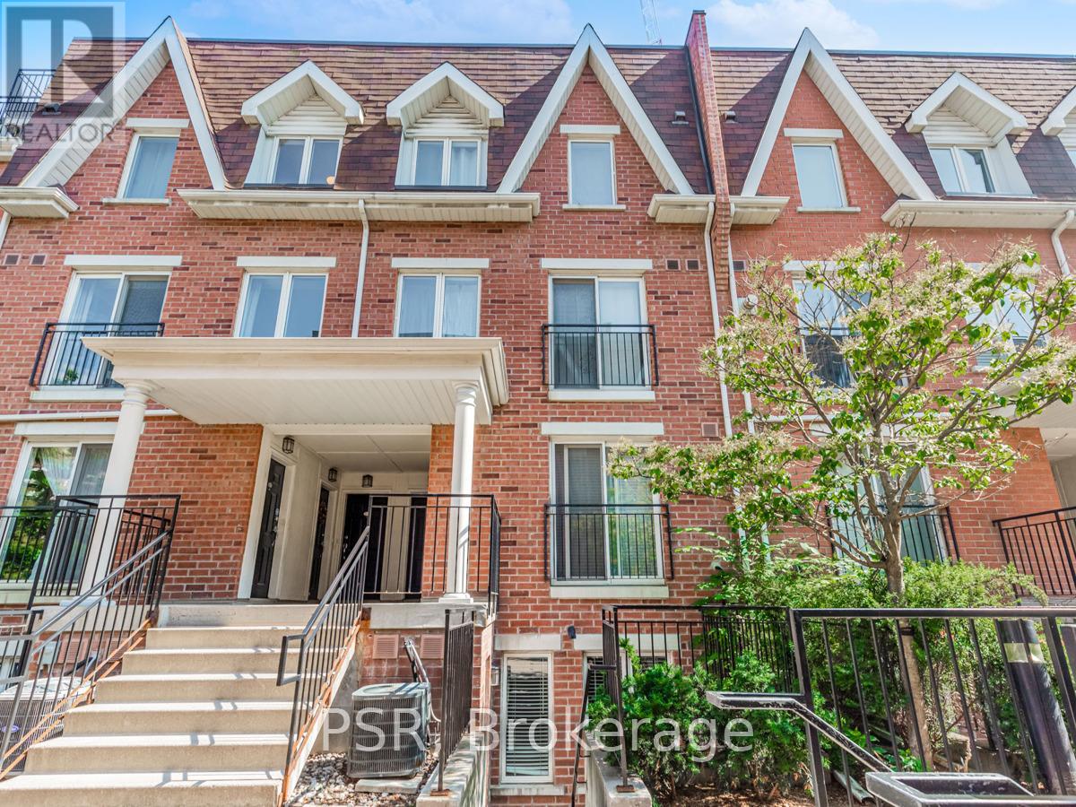 A red brick apartment building with a balcony and stairs leading to the front door.