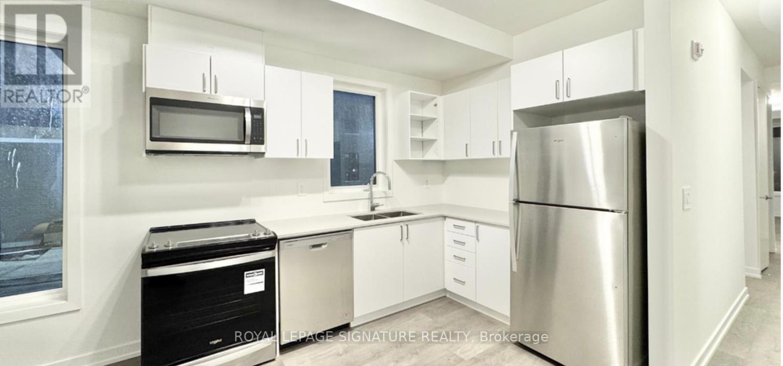 A kitchen with white cabinets and stainless steel appliances.