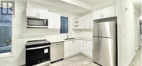 A kitchen with white cabinets and stainless steel appliances.