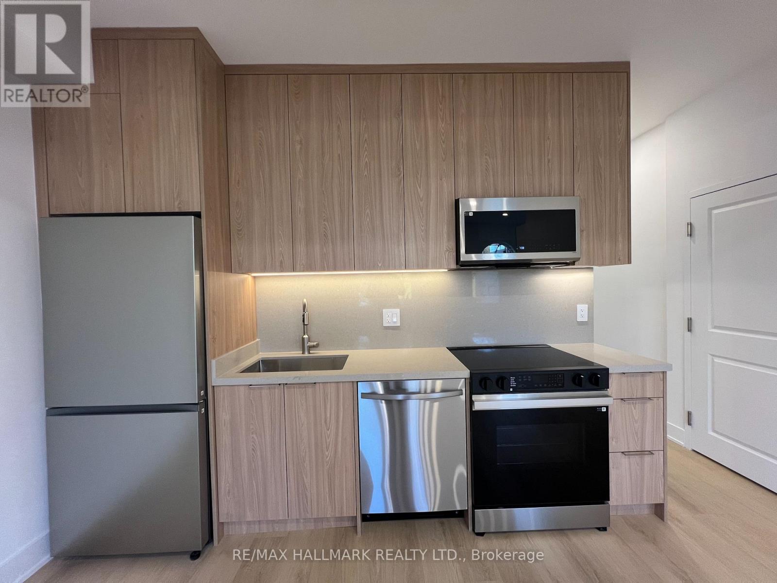 A kitchen with a stainless steel refrigerator, oven, and microwave.