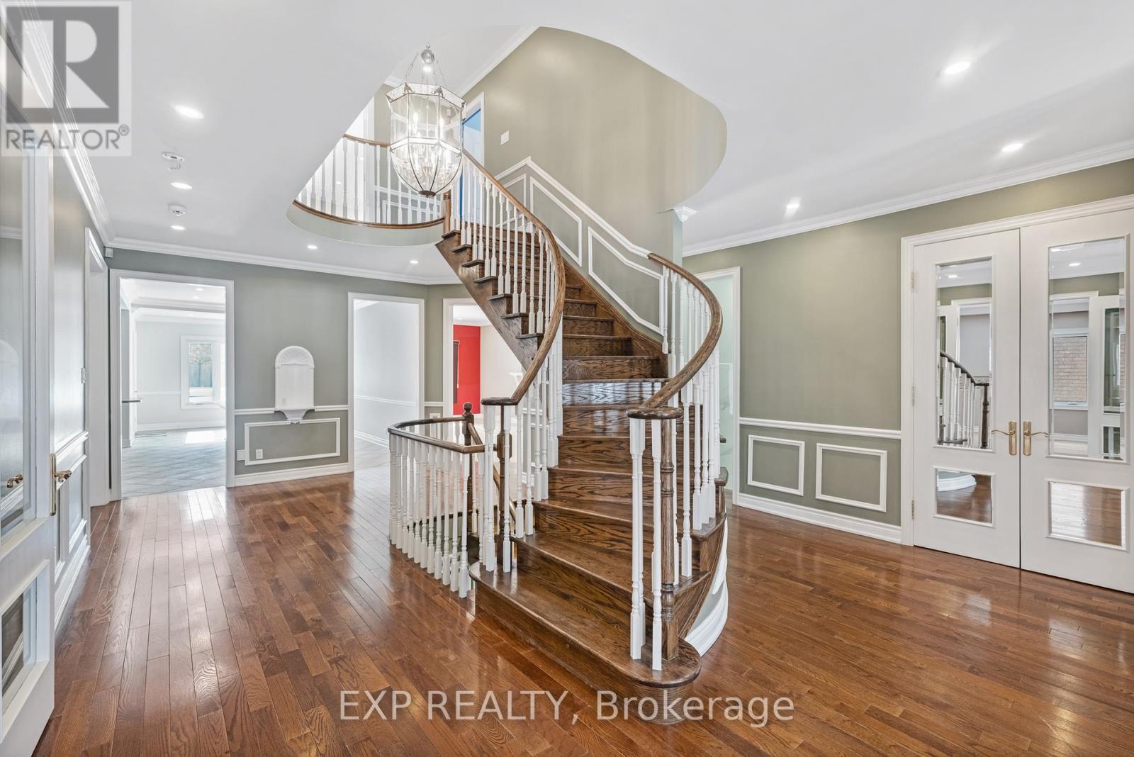 A large, well-lit, and spacious home interior with a curved staircase.