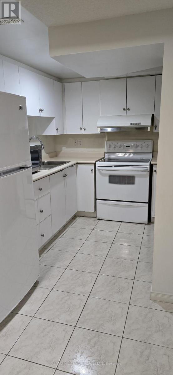 A kitchen with white cabinets and appliances.