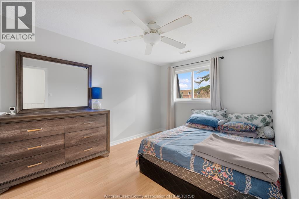 A bedroom with a bed, dresser, and mirror.