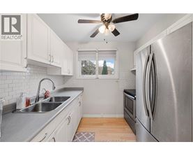 A kitchen with a stainless steel refrigerator and a ceiling fan.