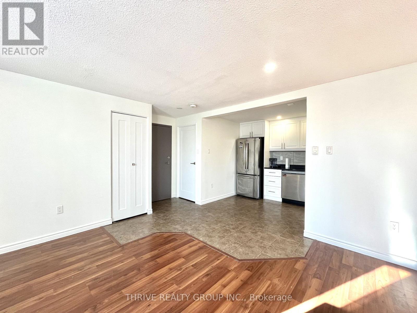 A kitchen with white walls and wooden floors.
